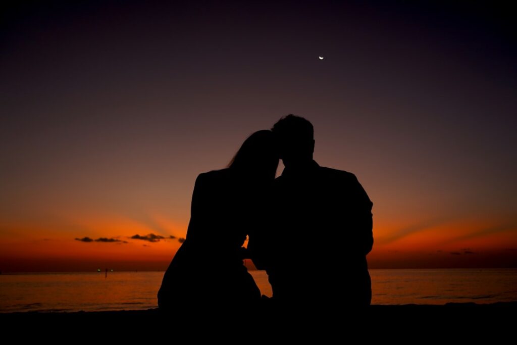 Couple watching sunset silhouette