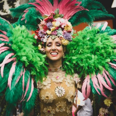 Vrouw in kleurrijk carnavalskostuum met veren