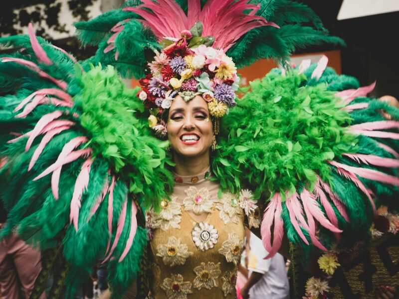Vrouw in kleurrijk carnavalskostuum met veren