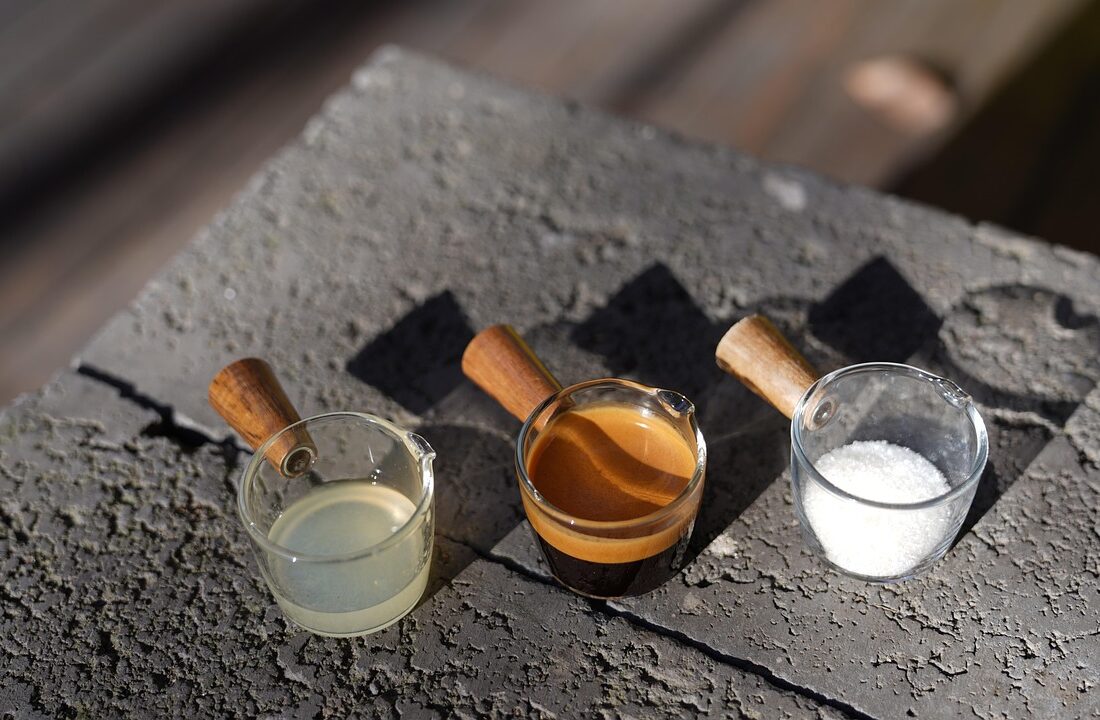 Drie koffieshots in glazen op een muurtje