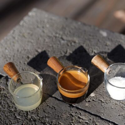 Drie koffieshots in glazen op een muurtje