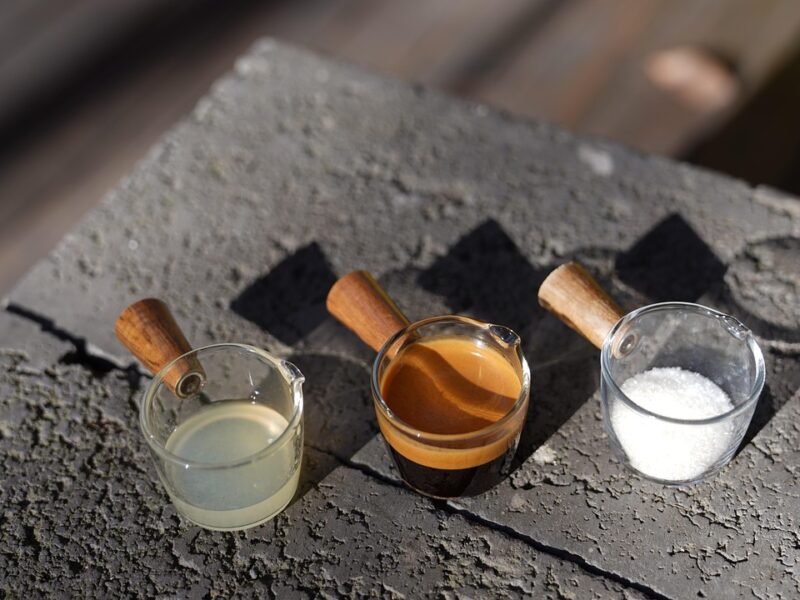 Drie koffieshots in glazen op een muurtje