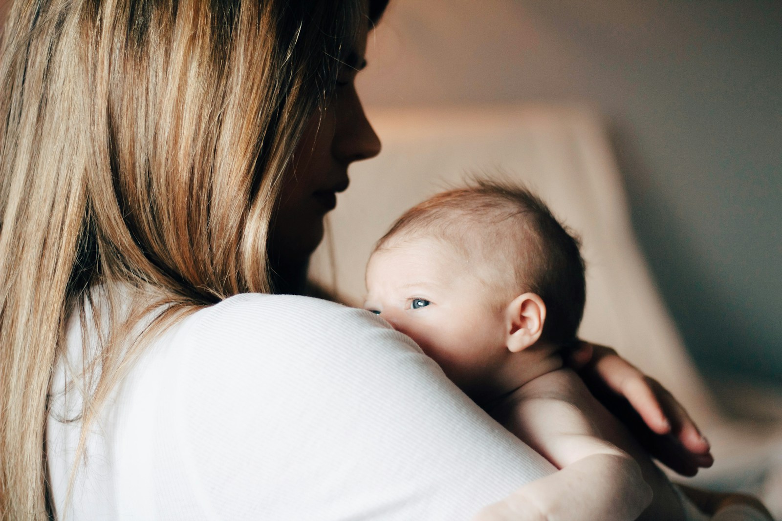 Moeder houdt een pasgeboren baby tegen zich aan