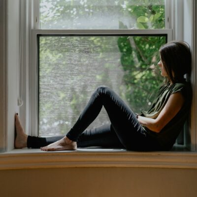 Vrouw zit rustig in de vensterbank