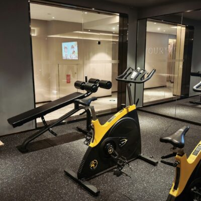 A modern gym with exercise bikes and a weight bench