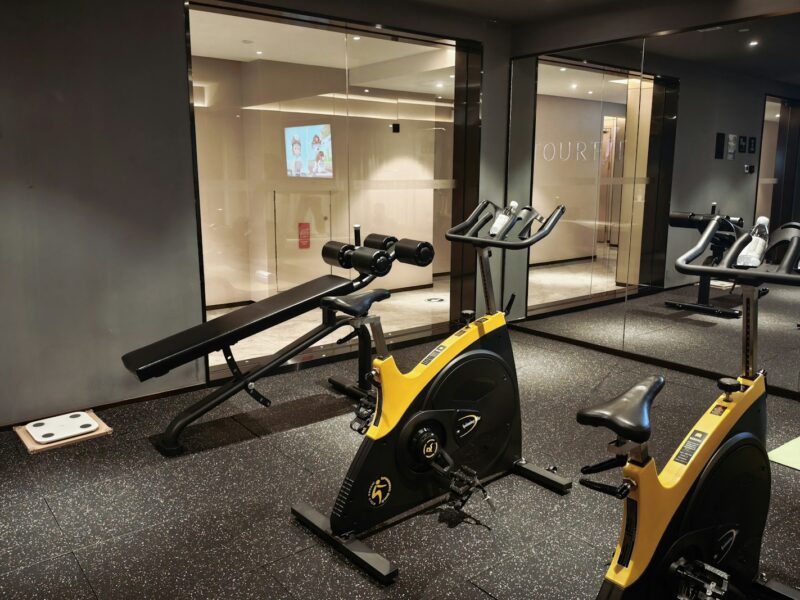 A modern gym with exercise bikes and a weight bench