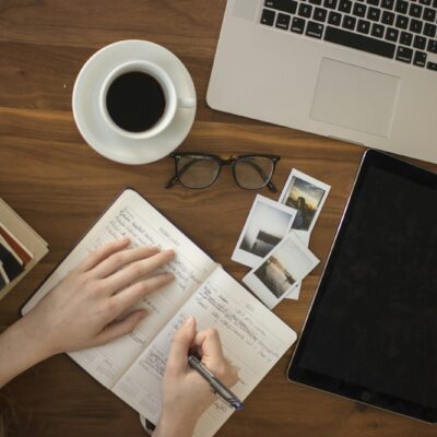 Opengeslagen notitieboek met pen op een houten tafel bij avondlicht