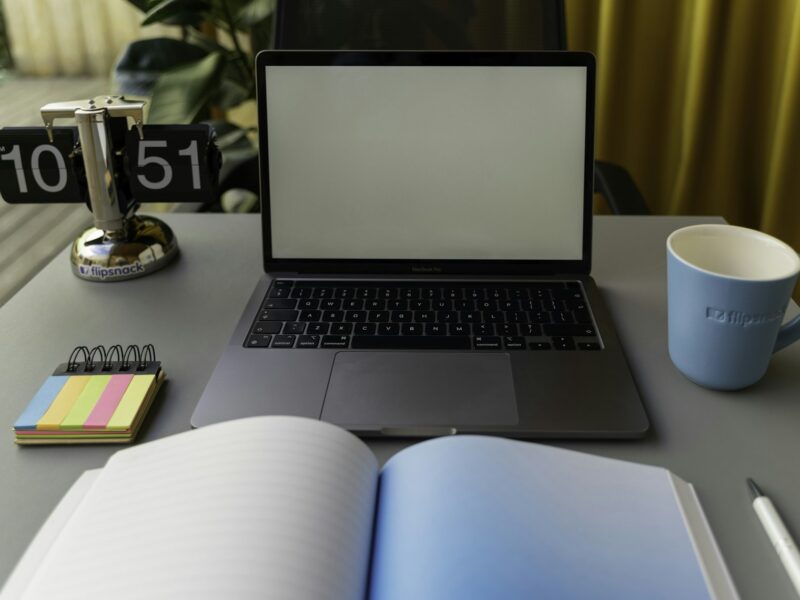 Bureau met een open notitieboek, een timer en een weggelegde telefoon