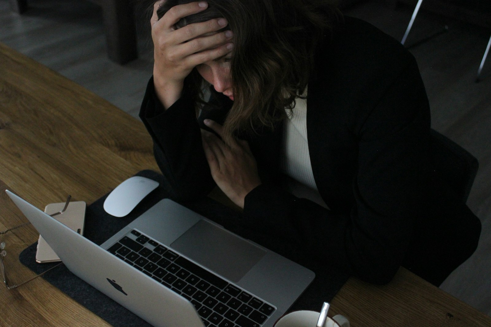 Vermoeide werknemer met het hoofd in de handen achter een laptop