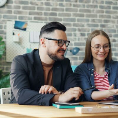 Twee collega's in gesprek aan een tafel op kantoor