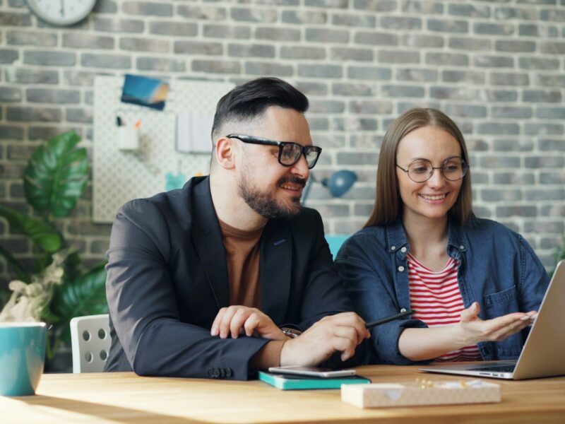 Twee collega's in gesprek aan een tafel op kantoor