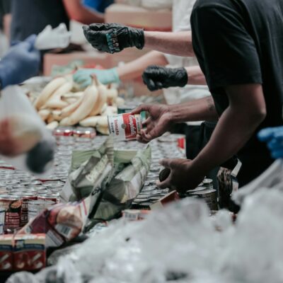 Vrijwilligers pakken samen voedselpakketten in aan een lange tafel