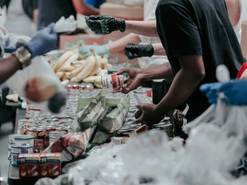 Vrijwilligers pakken samen voedselpakketten in aan een lange tafel