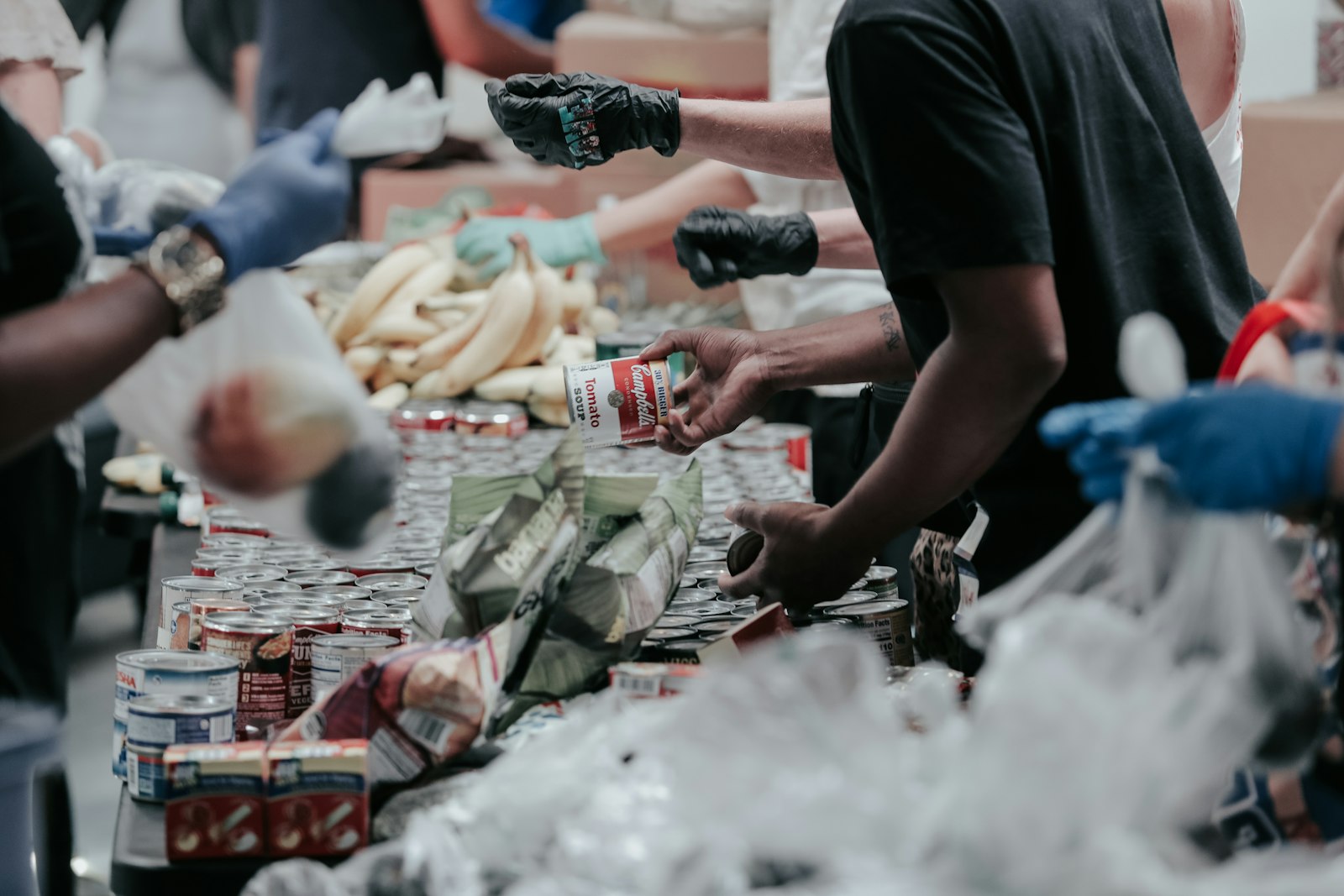 Vrijwilligers pakken samen voedselpakketten in aan een lange tafel