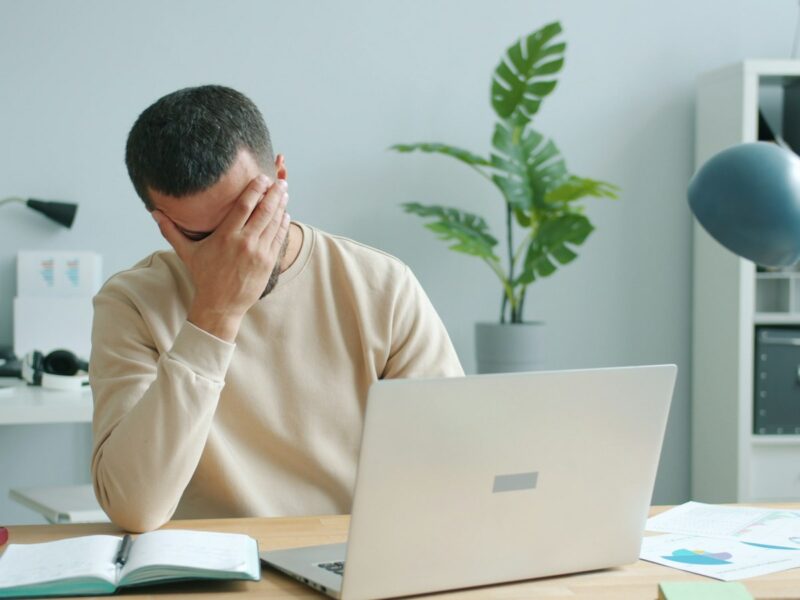 Werknemer zit alleen aan een bureau in een stil kantoor