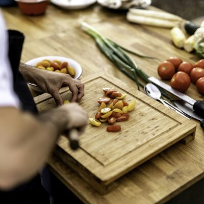 Vrouw geeft een kookworkshop aan een groep deelnemers in een kookstudio