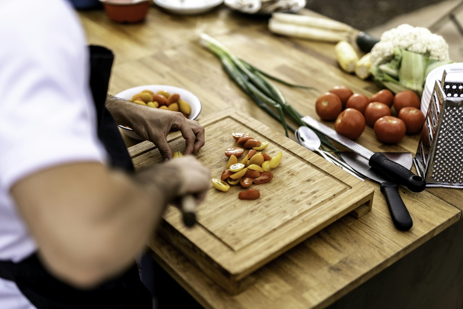 Vrouw geeft een kookworkshop aan een groep deelnemers in een kookstudio