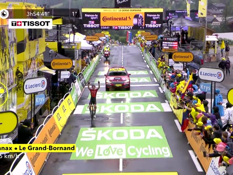 Dylan Teuns komt juichend over de finish in Le Grand-Bornand in de Tour de France van 2021