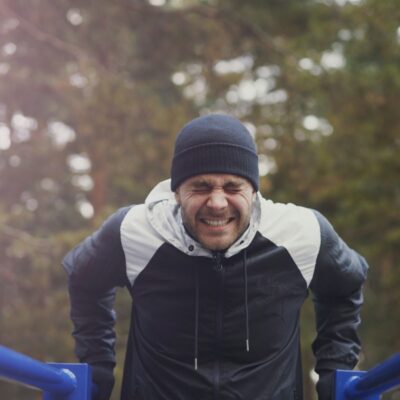 Man van middelbare leeftijd doet krachtoefeningen met een dumbbell in een sportschool
