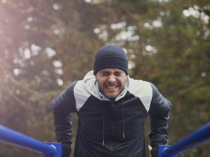 Man van middelbare leeftijd doet krachtoefeningen met een dumbbell in een sportschool