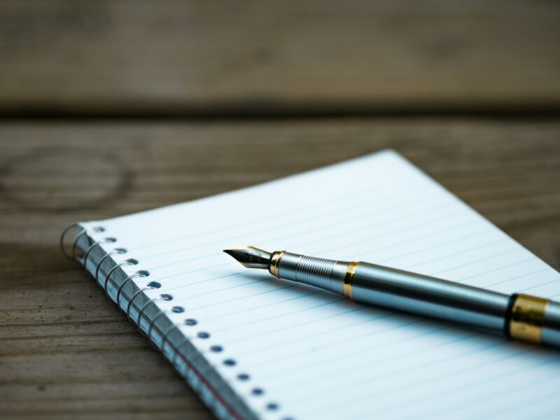 Notitieboek met een geschreven plan en een pen op een bureau