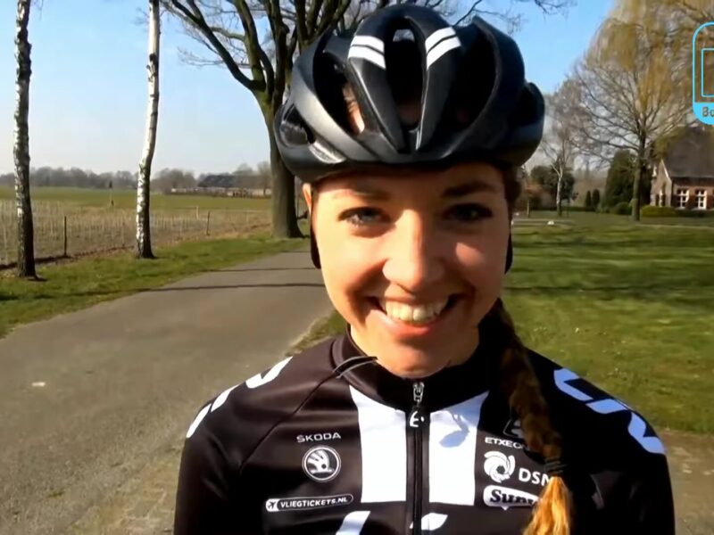 Wielrenster Sabrina Stultiens lacht in de camera tijdens een interview langs de weg