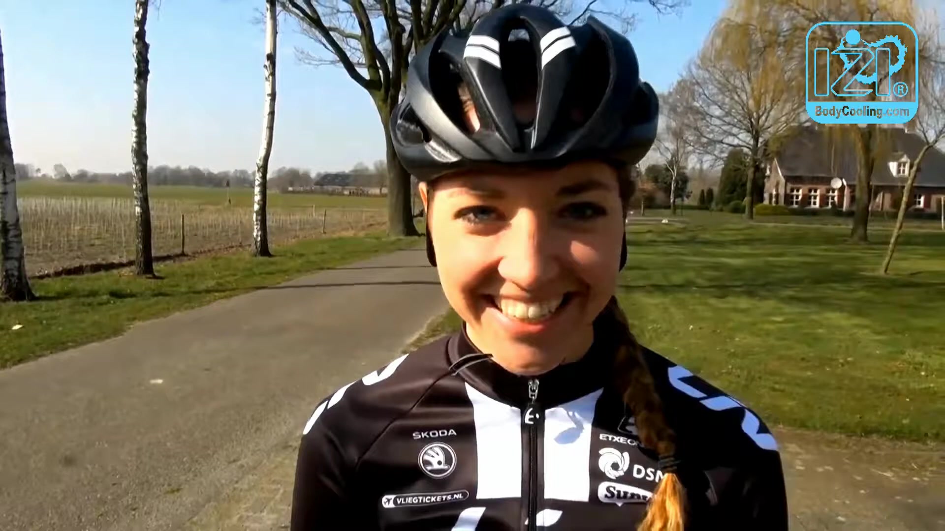 Wielrenster Sabrina Stultiens lacht in de camera tijdens een interview langs de weg