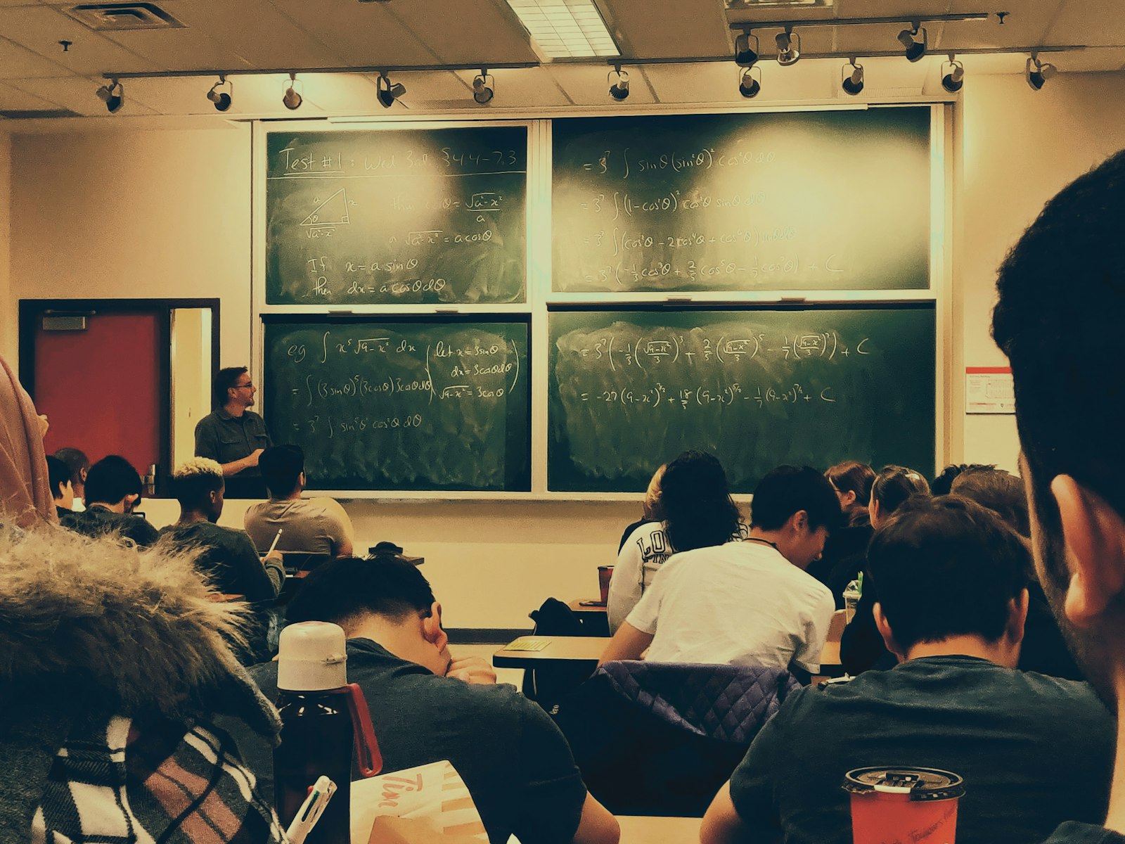 Volwassen studenten volgen een avondles in een collegezaal van een hogeschool