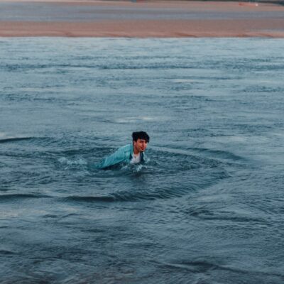 Zwemmers lopen in de herfst de zee in bij een kalm strand