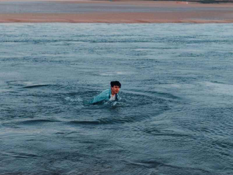 Zwemmers lopen in de herfst de zee in bij een kalm strand
