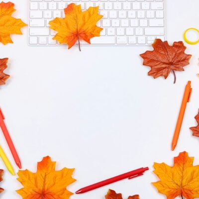 Opengeslagen agenda met een pen en een kop koffie op een houten bureau in herfstlicht