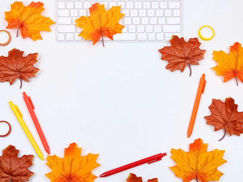 Opengeslagen agenda met een pen en een kop koffie op een houten bureau in herfstlicht