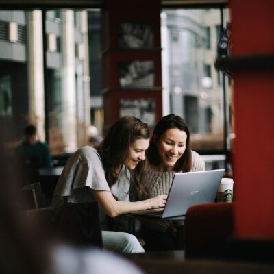 Jonge en oudere collega kijken samen naar een laptop op kantoor