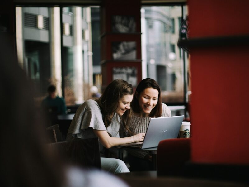 Jonge en oudere collega kijken samen naar een laptop op kantoor