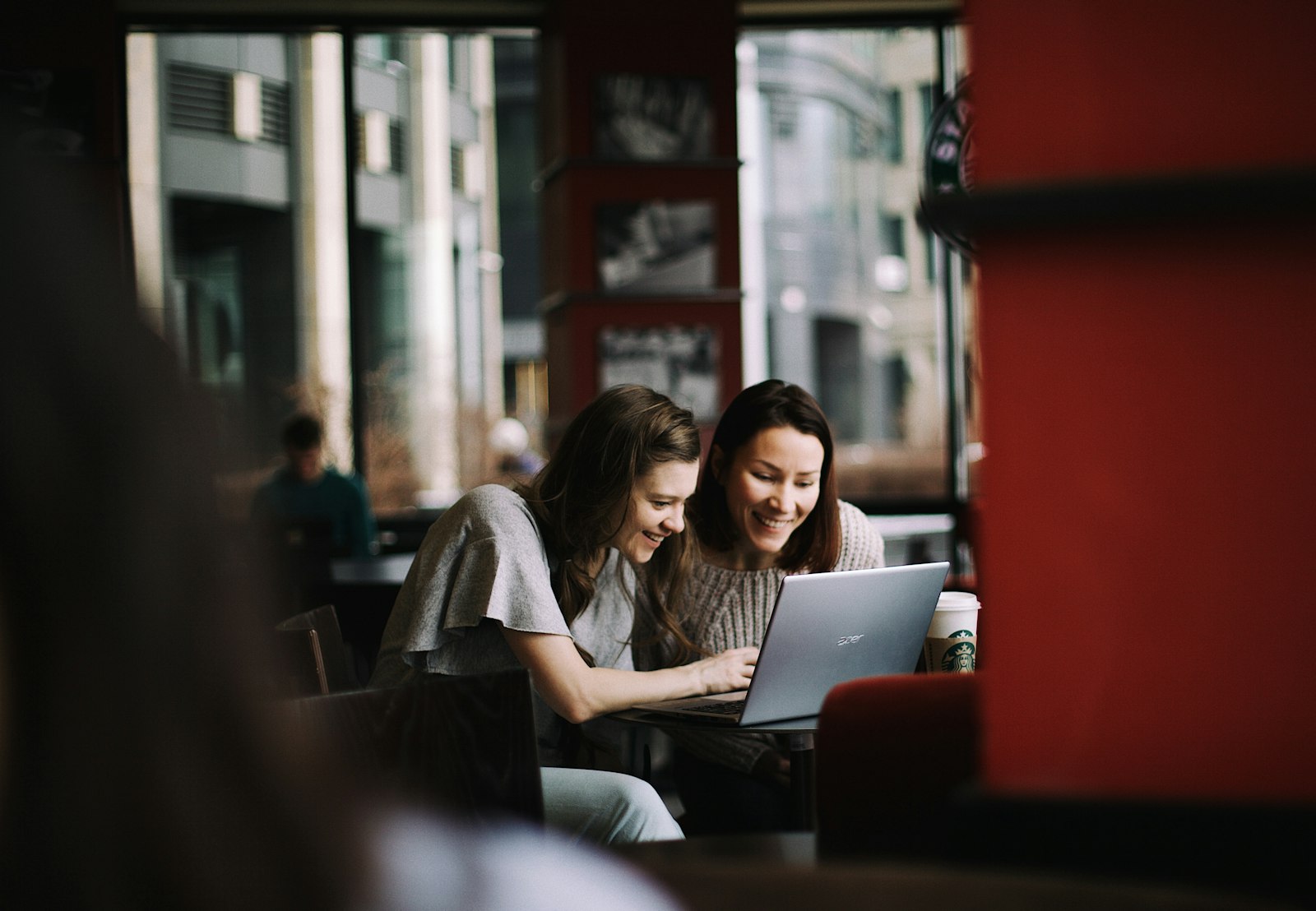 Jonge en oudere collega kijken samen naar een laptop op kantoor