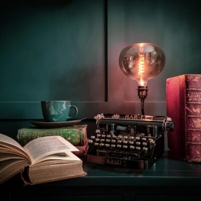 Iemand leest een boek onder een leeslamp op een herfstavond
