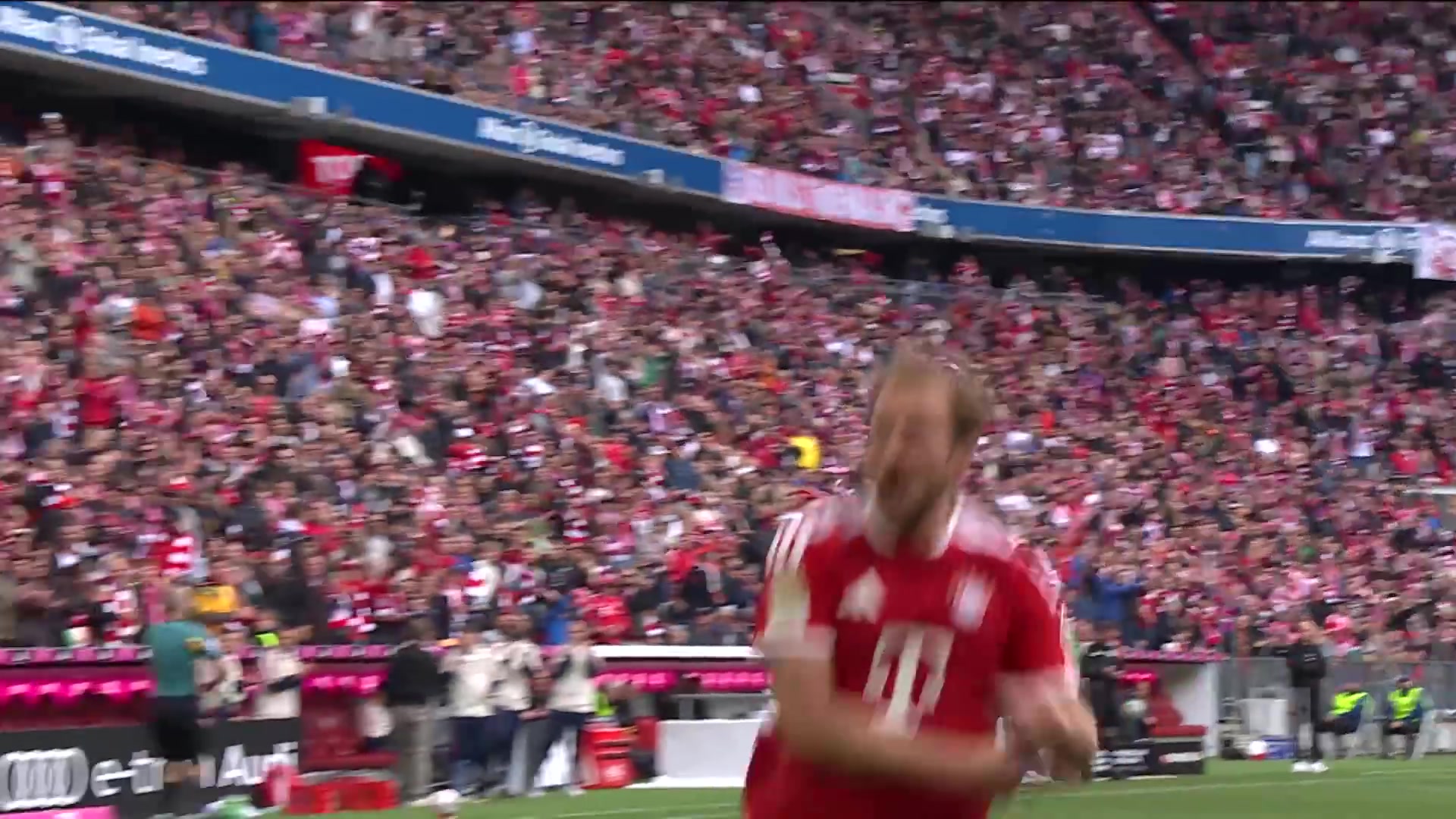 Harry Kane juicht in het rode shirt van Bayern München na een doelpunt