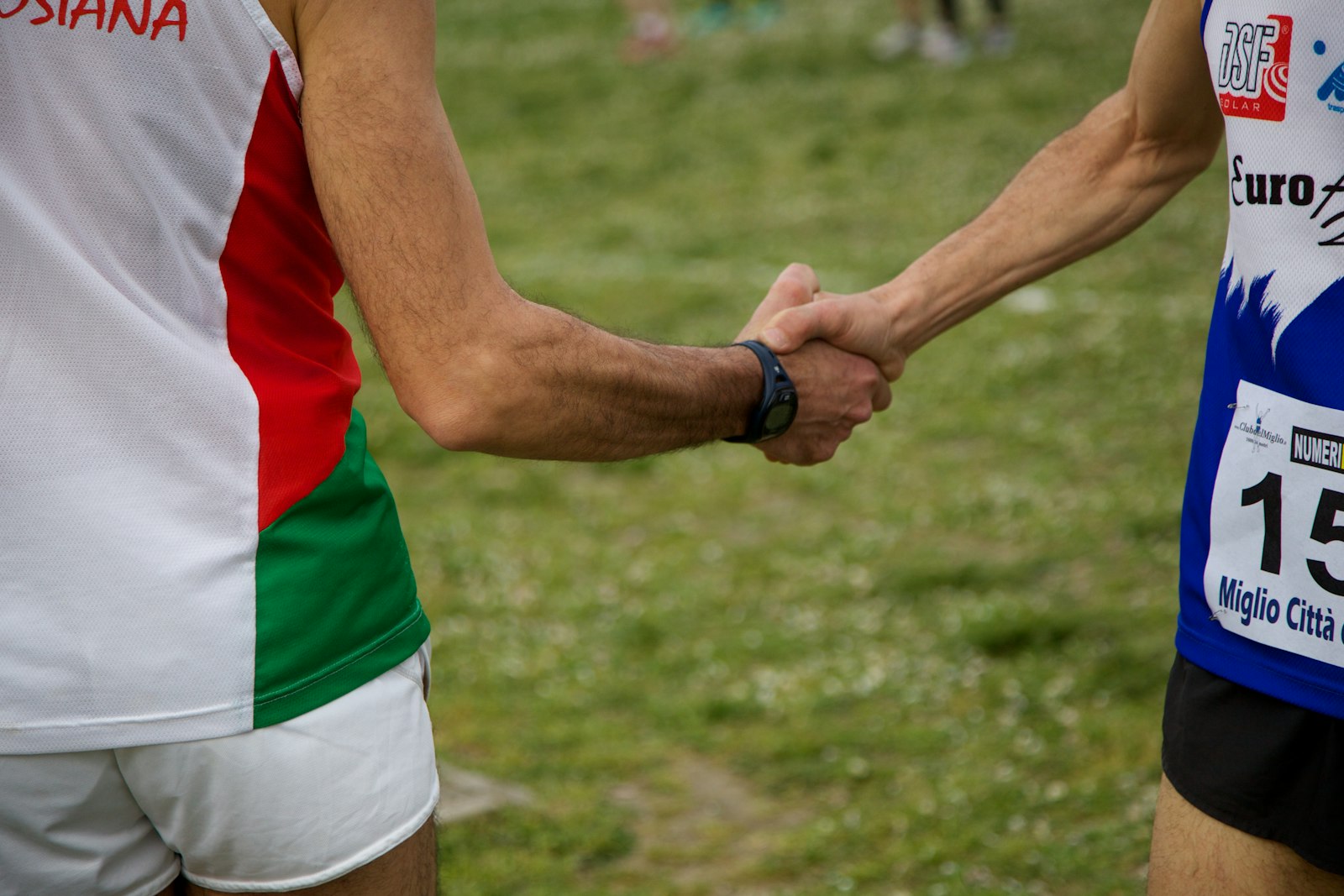 Atletes wisselen het estafettestokje op de atletiekbaan