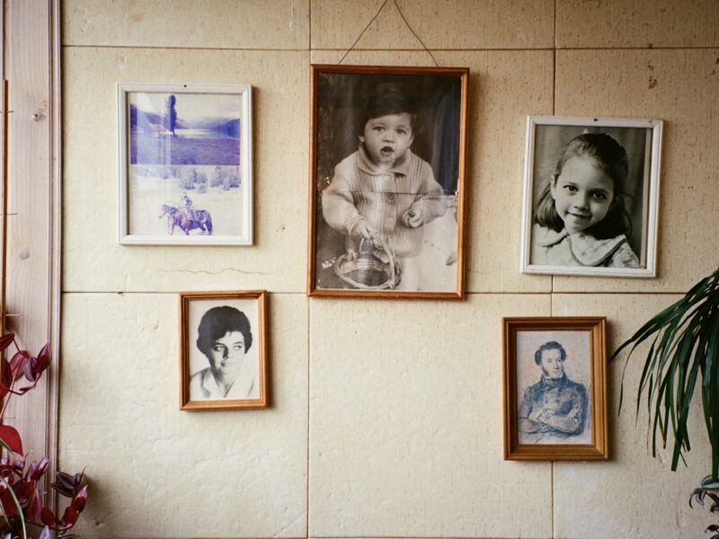Volwassen vrouw kijkt peinzend naar oude familiefoto's