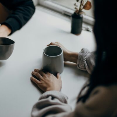 Twee mensen in gesprek bij een kop koffie