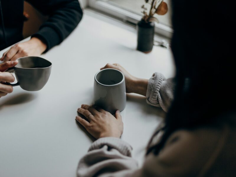 Twee mensen in gesprek bij een kop koffie