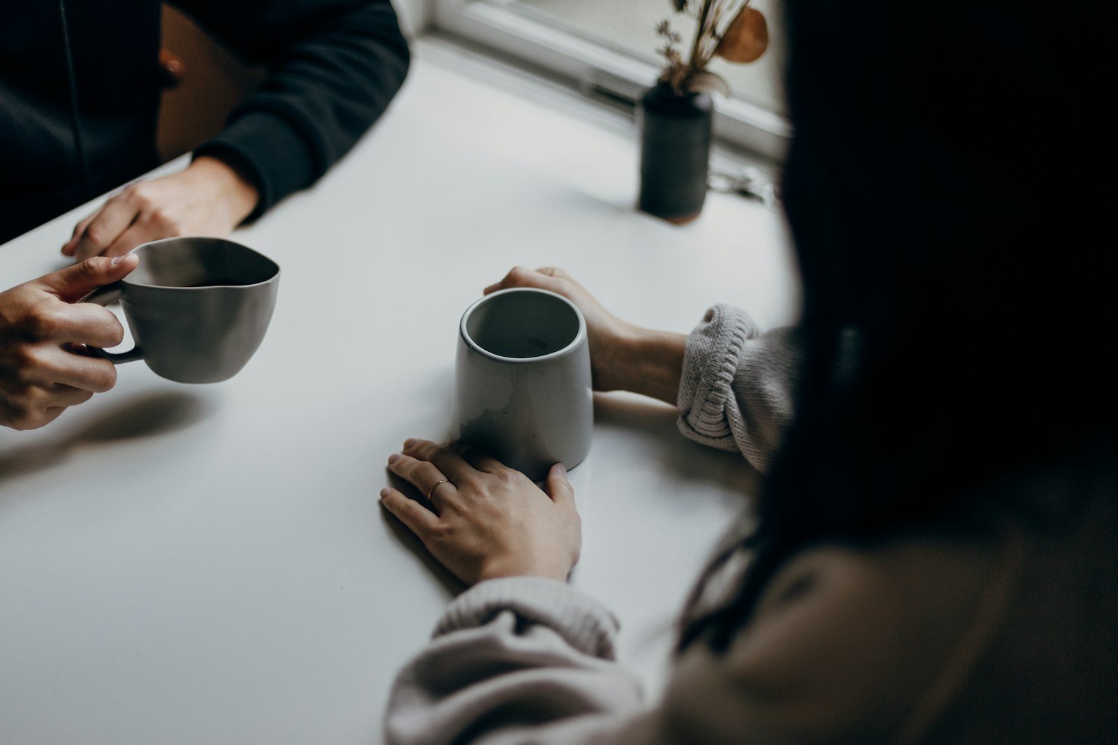 Twee mensen in gesprek bij een kop koffie