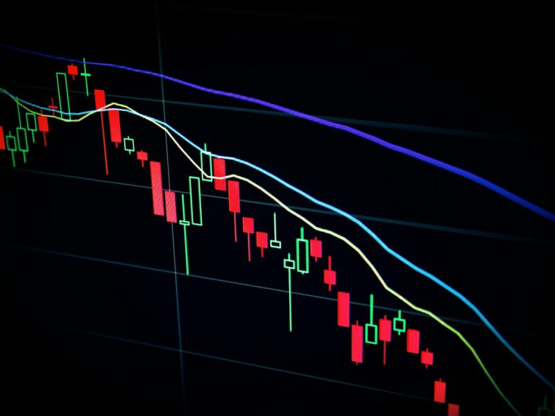 Munten en een koersgrafiek van cryptovaluta op een scherm