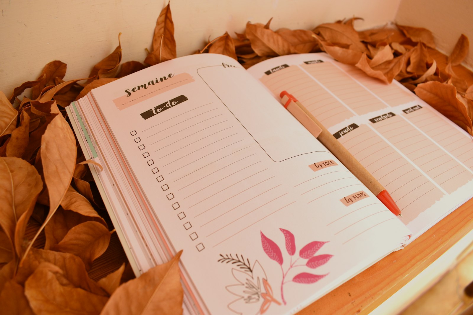Herfstbladeren op een tafel naast een open agenda