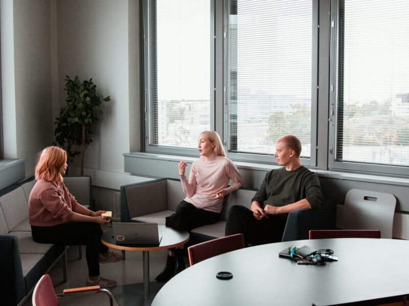 Twee collega's in gesprek aan een tafel op kantoor
