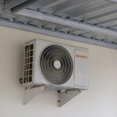 Monteur installeert de buitenunit van een warmtepomp bij een woning
