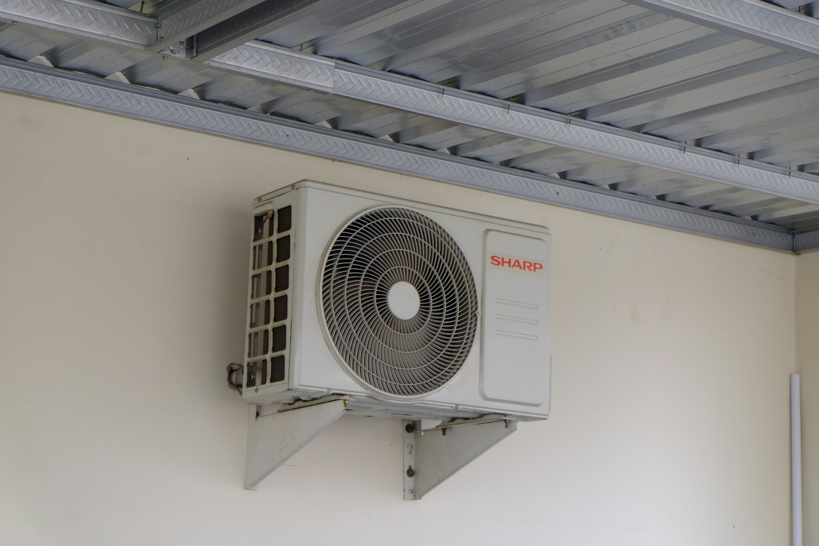 Monteur installeert de buitenunit van een warmtepomp bij een woning