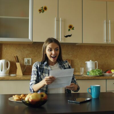 Iemand bekijkt aan de keukentafel een pensioenoverzicht op papier en laptop