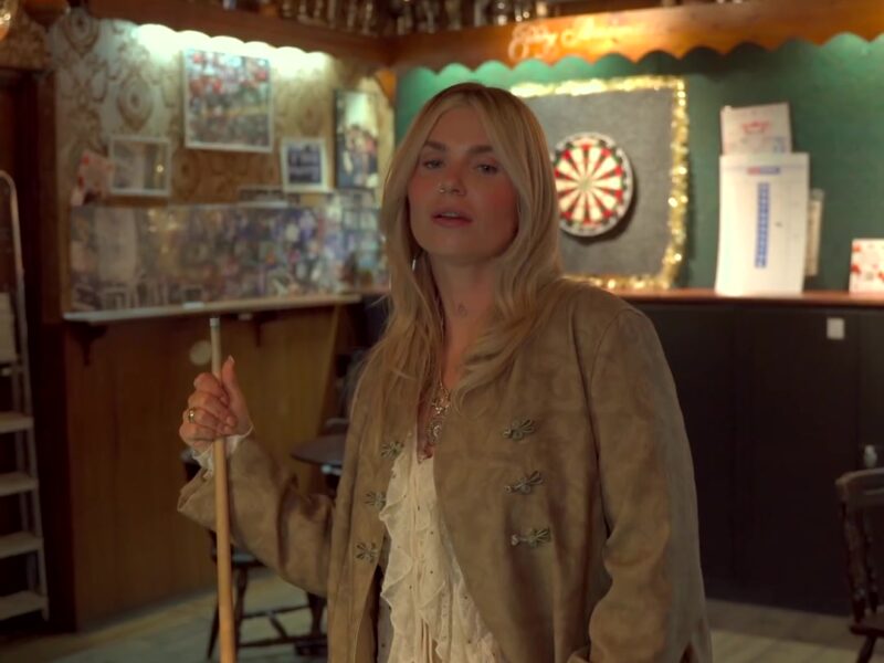 Roxeanne Hazes met een keu in een bruin café in de clip van Tranen in de giftshop
