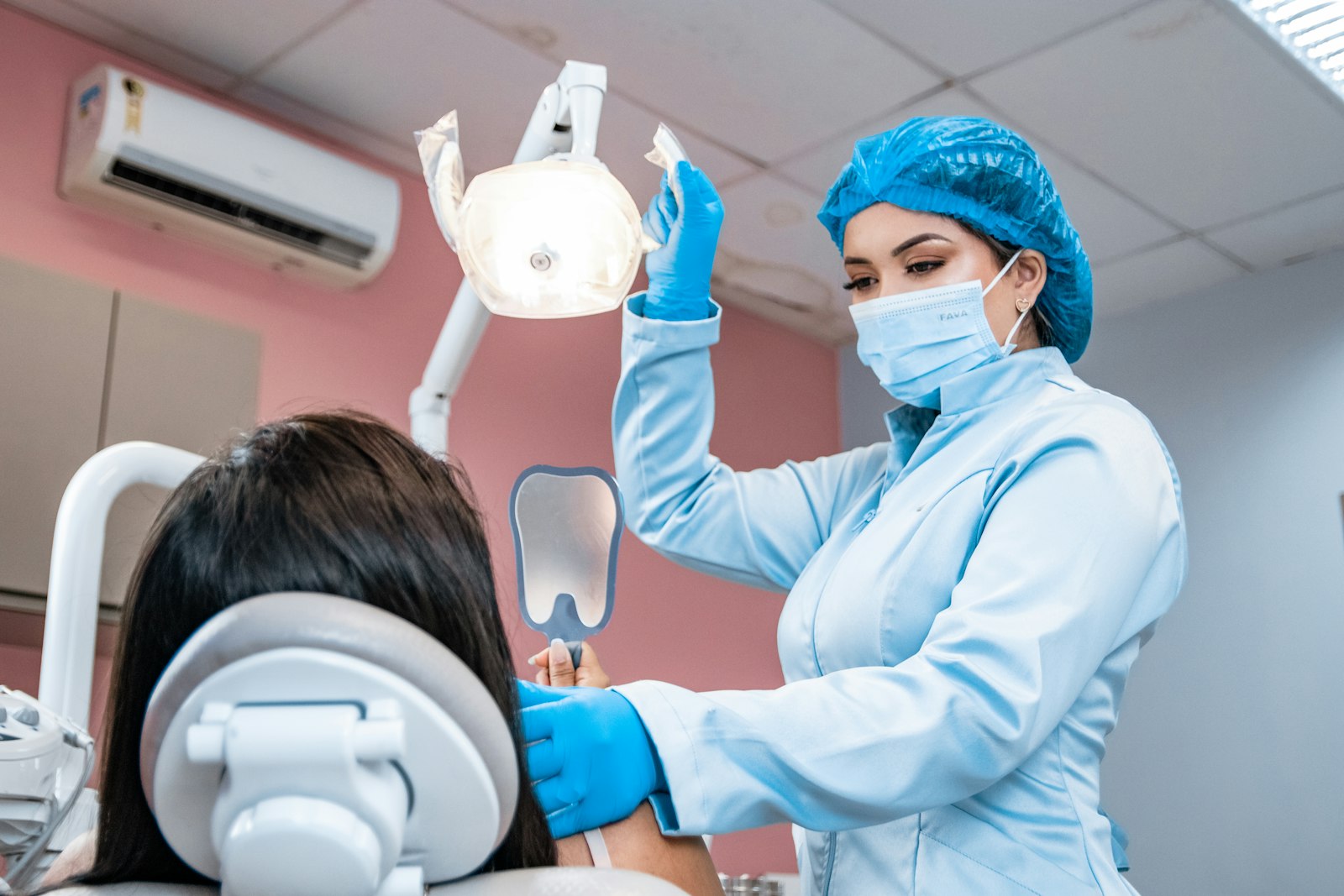 Mondhygiënist behandelt een patiënt in de stoel van een tandartspraktijk